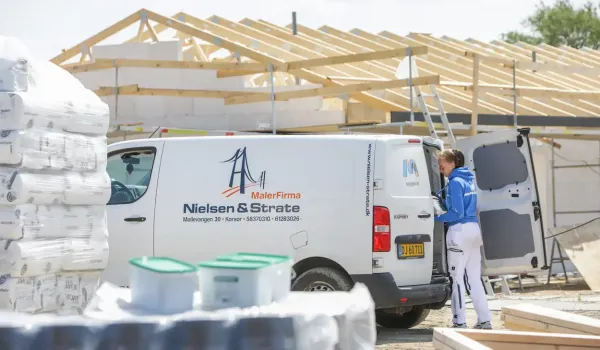 Maler fra malerfirmaet nielsen strate står ved firmabil